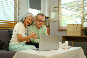 Happy mature couple sitting in the living room and talking to their doctor via video call. Telehealth concept