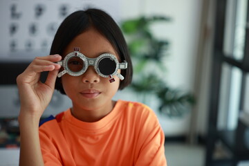 Elementary school girl wearing eyeglasses visual acuity test with test chart, eye test, Female patient checking eyesight in ophthalmology clinic, eye check