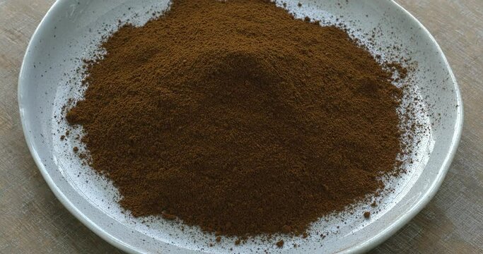 A heap of powdered chaga on a plate. Chaga tea is a strong antioxidant, boosts immune system, and has detox quality. Table spin.