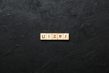 ulcer word written on wood block. ulcer text on table, concept