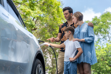 Family road trip vacation with electric vehicle, lovely family recharge EV car with green and clean...