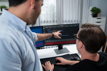 IT developers pointing on software development information on two screens with coding program in...