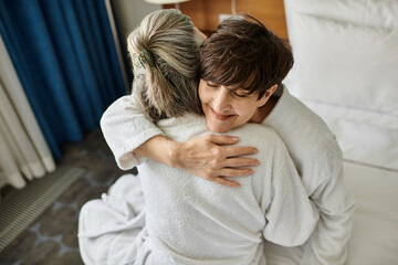Senior lesbian couple sharing a tender hug in a hotel.