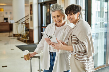 Older lesbian couple engrossed in tablet together.