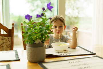 Cute little girl having breakfast in the morning at home. Healthy eating concept.