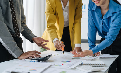 Teamwork Makes the Dream Work: Business professionals collaborate on a project, analyzing data and charts.  A dynamic scene depicting synergy and strategic planning in the modern workplace. 