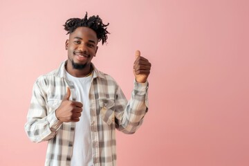 Studio portrait of happy african american man showing thumb up isolated on pink background.