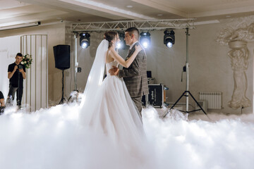 A bride and groom are dancing in the air with a cloud of smoke surrounding them. Scene is romantic...