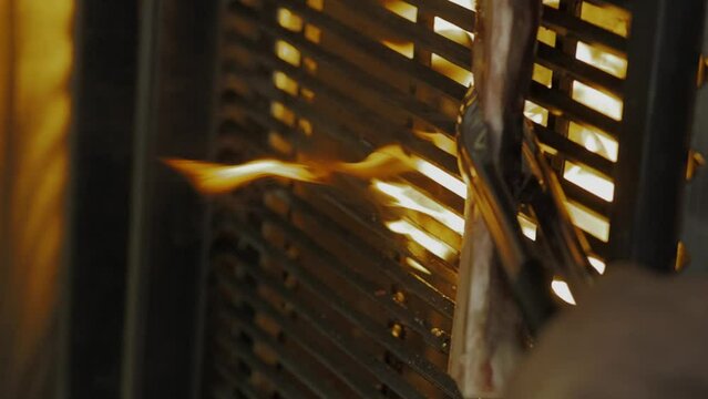 The process of cooking bone marrow on a grill over an open fire. Chef cooking on grill, close up, vertical video