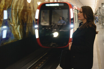 Beautiful lonely girl in black posing in the subway.