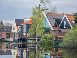 A picturesque scene of a charming row of houses lined up next to a peaceful body of water, creating a tranquil and idyllic setting