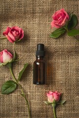rose essential oil on burlap background. selective focus