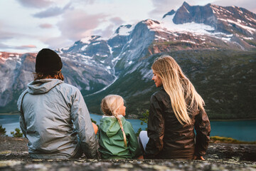 Family traveling together in Norway outdoor mother, father and child on summer vacations hiking adventure tour healthy lifestyle parents with daughter enjoying mountains and fjord view