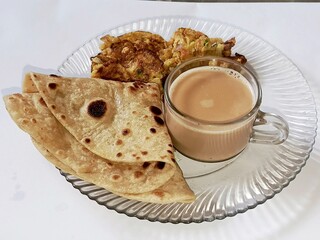 Pakistani breakfast with desi paratha, omelet and with a cup of tea    