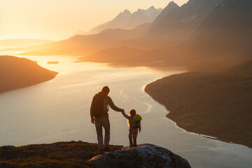 Father and child hiking in Norway traveling together summer vacations adventure trip healthy...