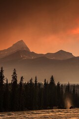  Inferno Sky: Dramatic Red Clouds Illuminated by Forest Fires in Banff National Park, Alberta,...