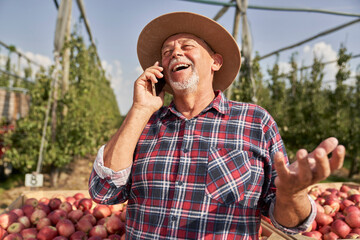 Cheerful senior farmer talking on the phone