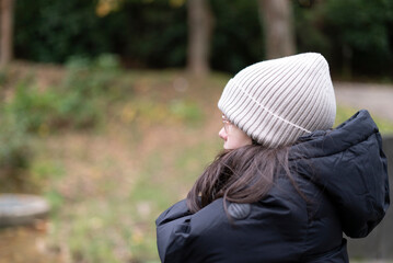 Portrait of a young girl in winter jacket and hat looking away
