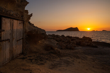 Sunset with a fishing hut at cala Comte beach, Sant Josep de Sa Talaia,  Ibiza, Balearic Islands,...