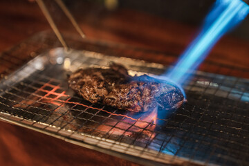 Chef using kitchen torch burn on wagyu beef