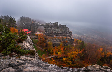 Hrensko, Czech Republic - Panoramic view of the famous Pravcicka Archway (Pravcicka Brana) in Bohemian Switzerland National Park, the biggest natural arch in Europe on a foggy day with autumn foliage