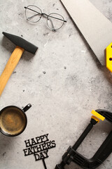 Flatlay composition with carpenters tools and coffee mug on stone table. Father's Day concept.