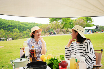 Two women camping and cooking outdoors