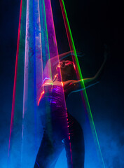 Beautiful woman dancing under colorful illumination, laser light, neon party night club....