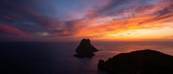 Panoramic view of Es Vedra island and Cap Jueu cape at sunset, viewed from the top of a cliff, Sant...