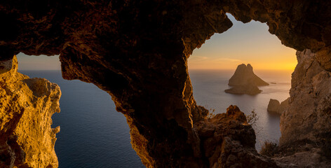 Es Vedra island sunset panorama viewed from a cave rock hole, Sant Josep de Sa Talaia, Ibiza,...