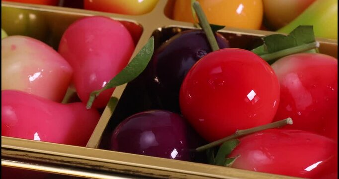 Colourful fruit vegetable shaped Thai sweet mung bean coconut milk desert luk chap candy variety pan rotate move