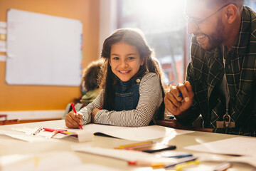 Happy little girl looking at the camera in an art and drawing class