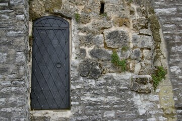 Rustic metal door in stone castle wall. Austria. 