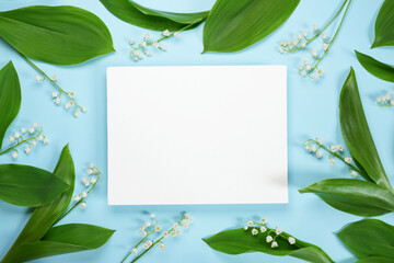 Blank frame with spring Lily of the valley flowers on a blue background. Wedding, Womens day,...