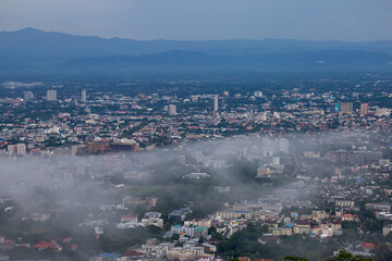 Naklejka premium High-angle view of the city with mist passing through. Many buildings in Chiang Mai, Thailand