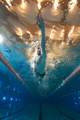 sports advertising underwater photography of a swimmer in a pool swimming freestyle in a sports...