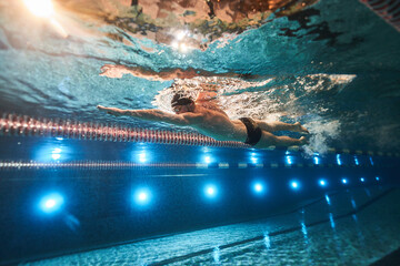 sports advertising underwater photography of a swimmer in a pool swimming freestyle in a sports...