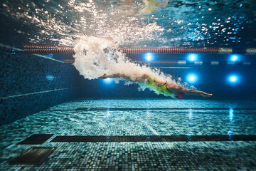 a beautiful young athletic girl in a yellow swimsuit and swimming goggles swims in a sports pool. underwater photography