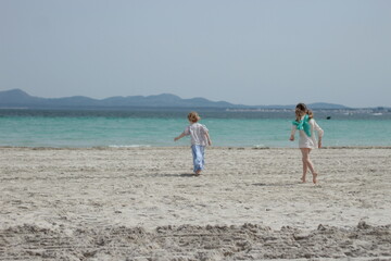 Gorgeous children running towards the sea in Spain