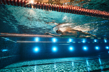 an athletic man swims in the pool. swimmer. underwater photography. freestyle swimming