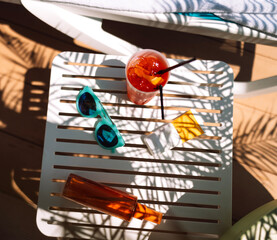 Sunscreens, sunglasses and a delicious chilled cocktail on the pool table