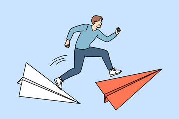 Man leader overcomes dangerous moments in business, runs on large paper airplanes to meet deadline. Ambitious guy wants become leader and be first to overcome path to career success