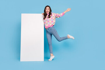 Full size photo of young lovely cheerful girl present promo advert isolated over blue color background