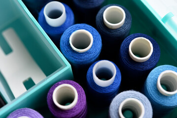 A set of colorful sewing threads. Skeins of thread in a plastic box.