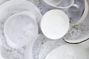 Dish washing, Dirty dishes soaking in kitchen sink.