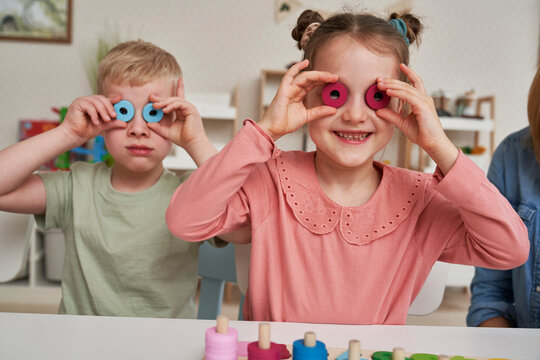 Little girl and boy having fun with Montessori toys