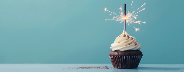 chocolate cupcake with sparkler, white cream, soft blue background, copyspace and text - Powered by Adobe