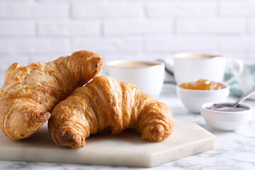 Tasty breakfast. Fresh croissants and jam on white marble table
