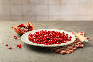 Tasty ripe pomegranate grains on grey table