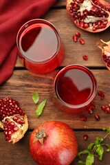 Tasty pomegranate juice in glasses and fresh fruits on wooden table, flat lay